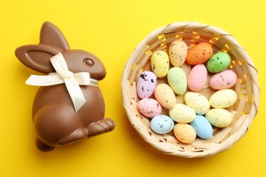 Çikolatalı Paskalya tavşanı ve sarı arka planda yumurtalar.