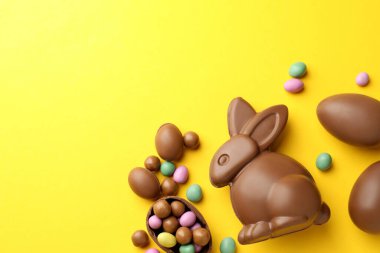 Çikolatalı Paskalya tavşanı ve sarı arka planda yumurtalar, düz yatak. Metin için boşluk