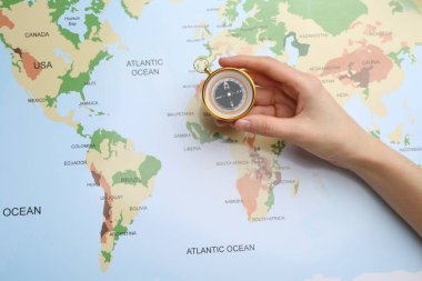 Yolculuk. Dünya haritasında pusula olan kadın, yukarıda görünüm