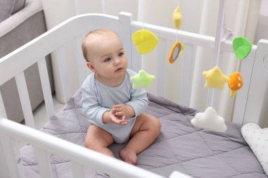 Evinde bebek karyolası olan küçük şirin bir bebek.