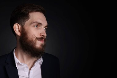 Siyah arka planda bıyıklı ve sakallı bir adam. Metin için boşluk