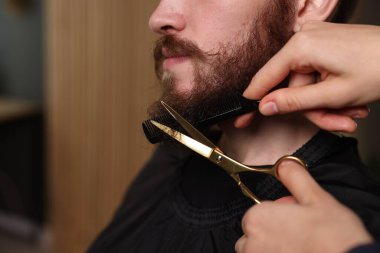 Berber dükkanında adamın sakalını buduyor, yakın plan. Metin için boşluk