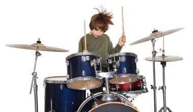 Beyaz arka planda bagetleri ve davulları olan küçük bir çocuk.