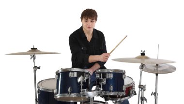 Bagetli genç çocuk beyaz arka planda davul çalmayı öğreniyor.