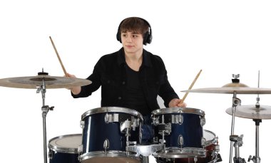 Kulaklıklı, bagetleriyle davul çalmayı öğrenen genç bir çocuk.