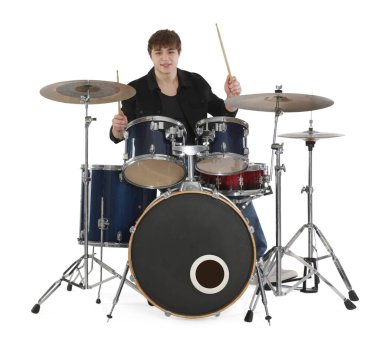 Elinde bagetlerle gülümseyen genç çocuk beyaz arka planda davul çalmayı öğreniyor.