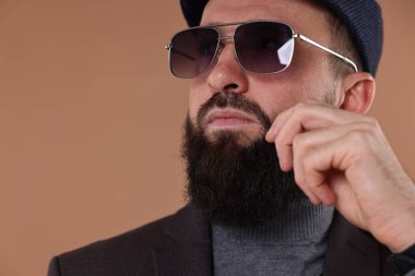 Bıyıklı ve sakallı adam bej arka planda, yakın plan. Metin için boşluk