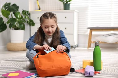 Okul için sırt çantasını toplayan bir kız. Metin için boşluk