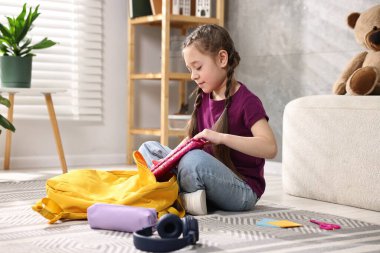 Okul için sırt çantasını toplayan bir kız. Metin için boşluk