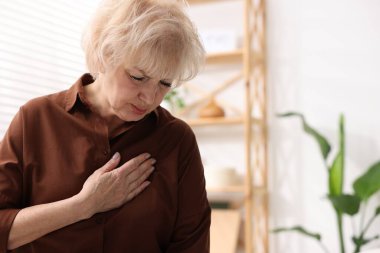Kalp krizi geçirdi. Göğüs ağrısı çeken son sınıf öğrencisi bir kadın, yakın plan. Metin için boşluk