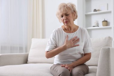 Kalp krizi geçirdi. İçeride göğüs ağrısı çeken yaşlı bir kadın. Metin için boşluk