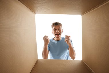 Adam beyaz arka planda karton kutuya bakıyor, içeriden görüntüle