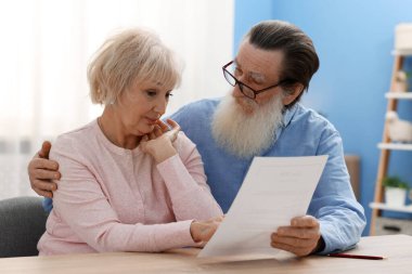 Ahşap masada son arzusu ve vasiyetnamesi olan yaşlı bir çift.