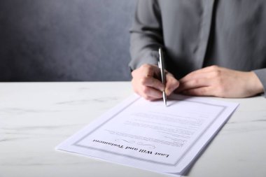 Beyaz mermer masada son arzusunu ve vasiyetini imzalayan kadın, yakın plan. Metin için boşluk