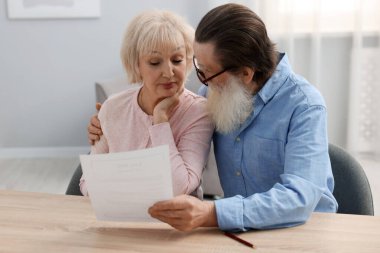 Ahşap masada son arzusu ve vasiyetnamesi olan yaşlı bir çift.