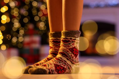 Evde Noel ağacına karşı rahat çorap giyen bir kadın, yakın plan.