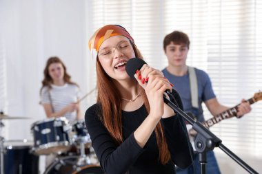 Genç müzik grubu içeride performanslarını prova ediyor.