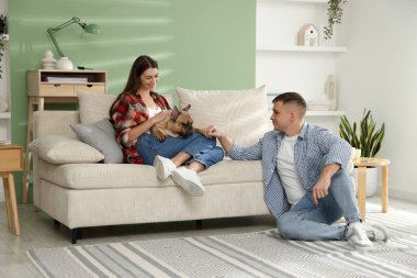 Evde dinlenen sevimli köpekli bir çift.