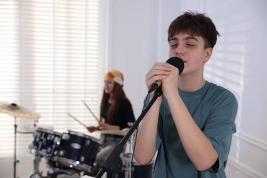 Genç müzik grubu kapalı alanda performanslarını prova ediyor, seçici odaklanma.