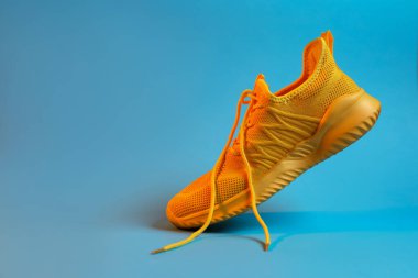 Açık mavi arka planda renkli şık bir spor ayakkabı, yakın plan. Metin için boşluk