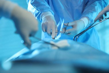 Tıbbi aletleri olan profesyonel cerrahlar ameliyathanede ameliyat yapıyorlar.