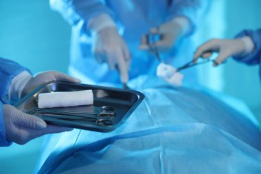 Tıbbi aletleri olan profesyonel cerrahlar ameliyathanede ameliyat yapıyorlar.