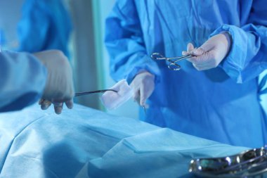 Tıbbi aletleri olan profesyonel cerrahlar ameliyathanede ameliyat yapıyorlar.