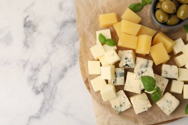 Farklı peynir, zeytin ve fesleğen içeren servis masası, üst manzara. Metin için boşluk