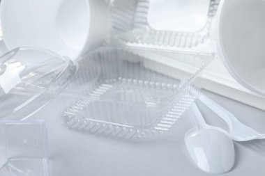 Aydınlık arkaplanda farklı plastik kaplar ve çatallar, yakın plan