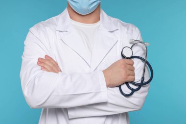 Açık mavi arka planda steteskobu olan doktor, yakın plan.