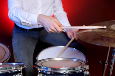 Kırmızı gradyan arkaplanda davul çalan adam, yakın plan