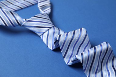 Mavi arka planda şık çizgili bir kravat, yakın plan.