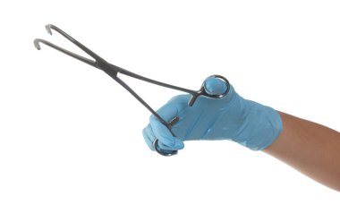 Beyaz arka planda metal havlu kıskacı tutan sağlık çalışanı, yakın plan.