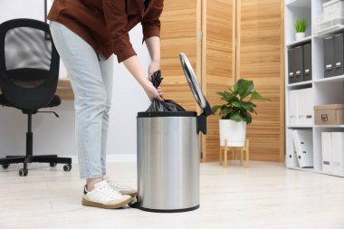 İçerideki çöp kutusundan plastik poşet çıkaran kadın, yakın plan.