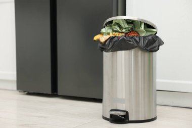 Mutfakta çöp dolu metal çöp tenekesi, metin için yer