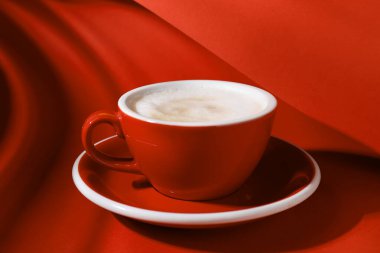 Kırmızı arka planda bir fincan aromatik kahve, yakın plan.