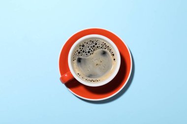 Açık mavi arka planda bir fincan aromatik kahve.