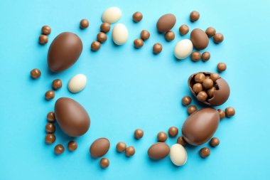 Açık mavi arkaplanlı çikolatalı Paskalya yumurtaları. Metin için boşluk