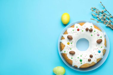Lezzetli Paskalya pastası, söğüt dalları ve açık mavi arka planda boyanmış yumurtalar. Metin için boşluk