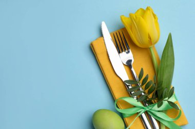 Paskalya kutlaması. Çiçek desenli ve açık mavi arka planda boyanmış yumurtalı şölen masası düzlüğü. Metin için boşluk