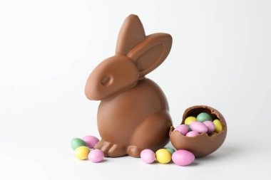 Çikolatalı Paskalya tavşanı ve beyaz arka planda şekerli yumurtalar.