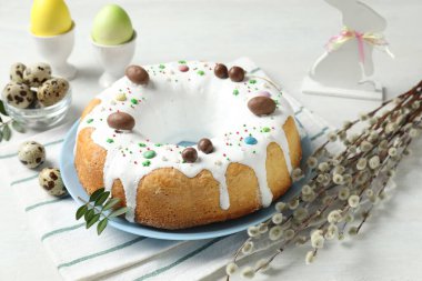 Lezzetli Paskalya pastası, tavşan figürü, söğüt dalları, bıldırcın ve beyaz masaya boyanmış yumurtalar, yakın plan.