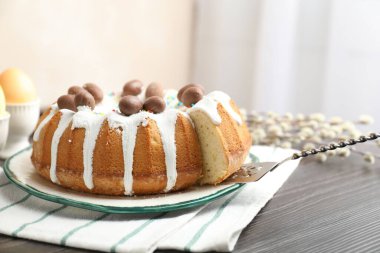 Çikolatalı yumurtalı, sunuculu ve söğüt dallı lezzetli Paskalya pastası, kapalı masa, yakın plan.