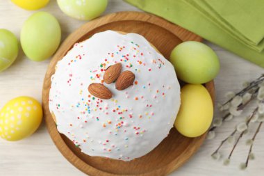 Lezzetli Paskalya pastası, boyanmış yumurtalar ve söğüt dalları beyaz ahşap masa üzerinde, düz uzanmış