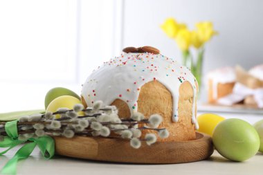 Lezzetli Paskalya pastası, boyanmış yumurtalar ve söğüt dalları beyaz ahşap masa üzerinde, yakın plan.