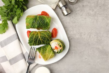 Gri masada servis edilen lezzetli lahana dürümleri. Metin için boşluk