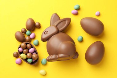 Çikolatalı Paskalya tavşanı ve sarı arka planda yumurtalar.
