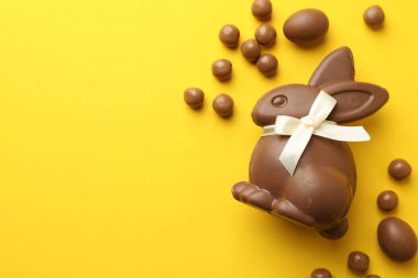 Çikolatalı Paskalya tavşanı ve sarı arka planda yumurtalar, düz yatak. Metin için boşluk