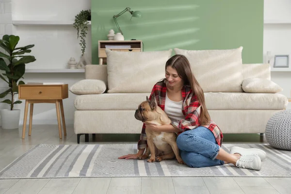 Evdeki kanepenin yanında sevimli köpeği olan bir kadın.