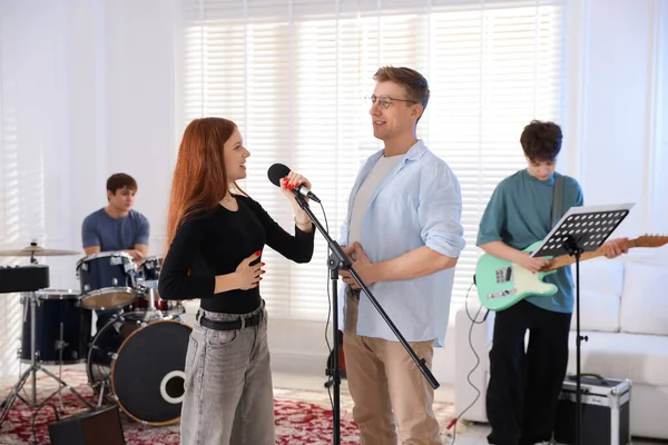 Gençlik bandosu içeride müzik öğretmeniyle performans çalışması yapıyor.